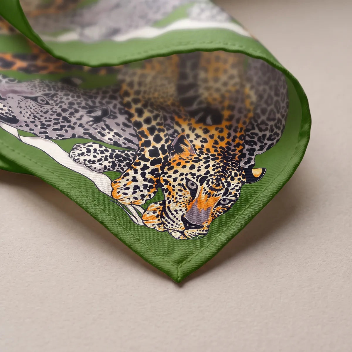 Corner of the gray leopard shawl: an orange leopard lying along the green border and a thin white line