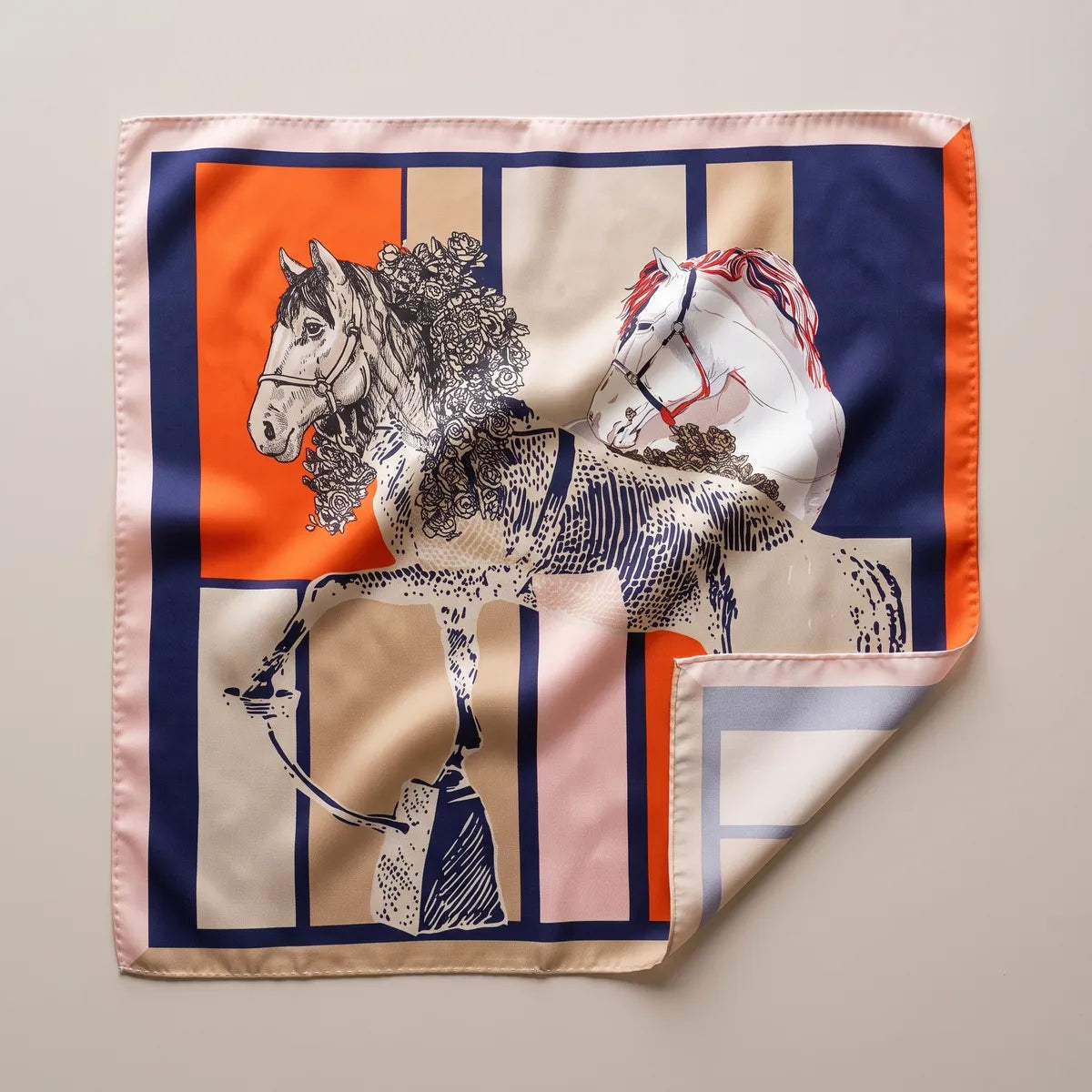 Orange and navy horse print silk square scarf laid flat: sketched horse heads over orange, navy, beige and pink blocks