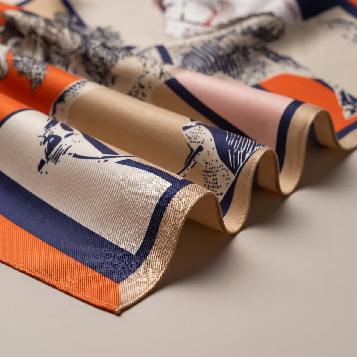 Folds of the color-block horse scarf: orange and navy bands, beige panels and a hatched horse leg