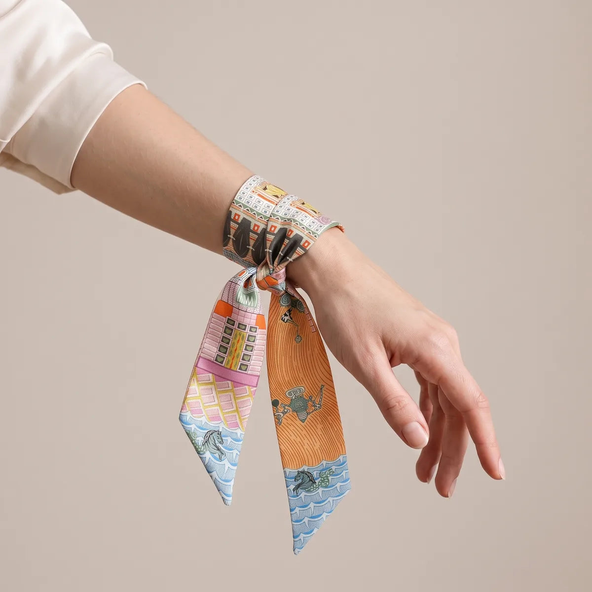 Orange and pink skinny silk and satin scarf tied around the wrist, blue tips showing