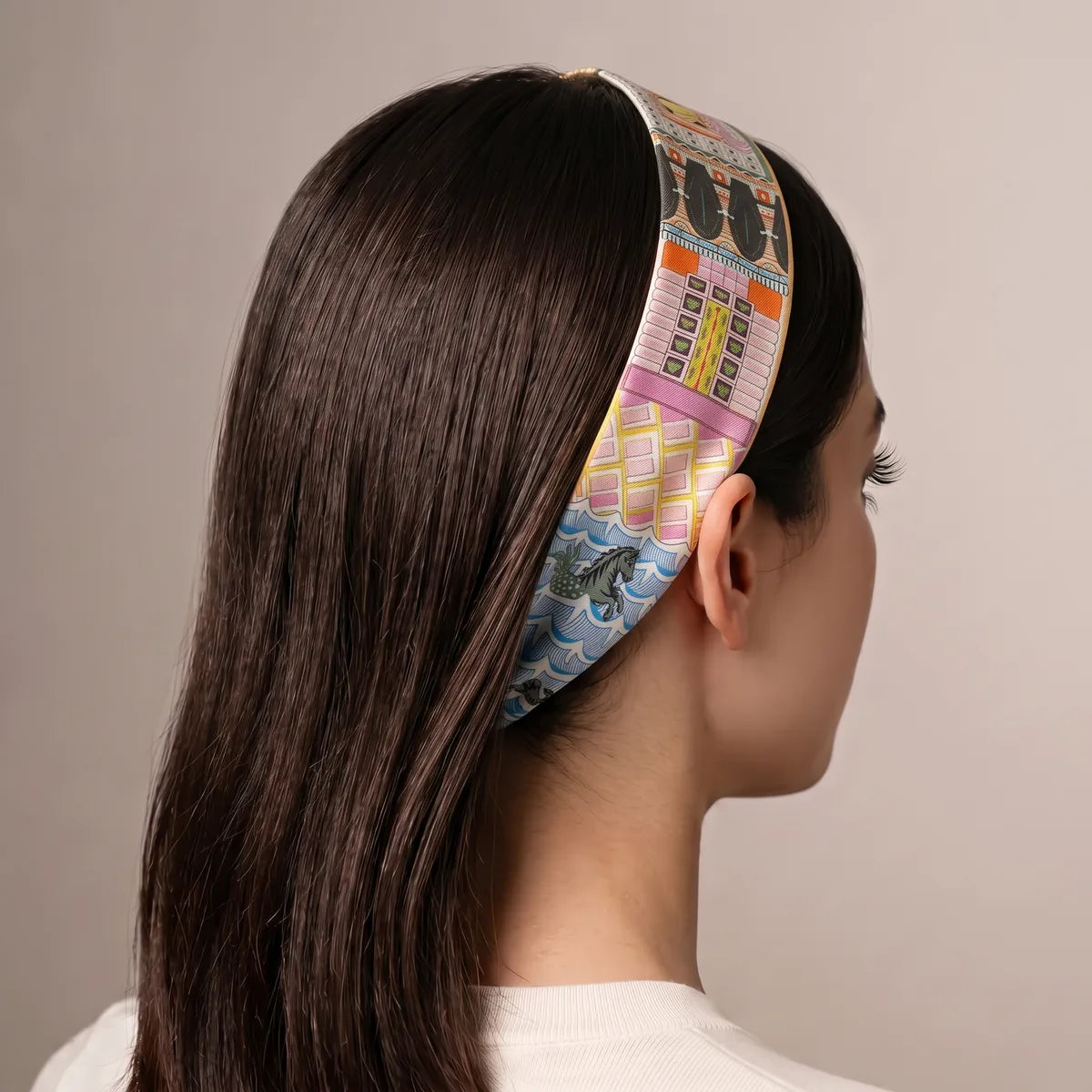 Pink facade strand of the orange skinny scarf worn as a headband, blue waves and a seahorse near the ear