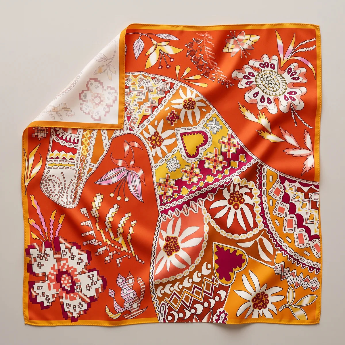 Orange patchwork floral silk shawl laid flat: hearts, daisies and cross-stitch flowers in stitched-look panels, corner folded