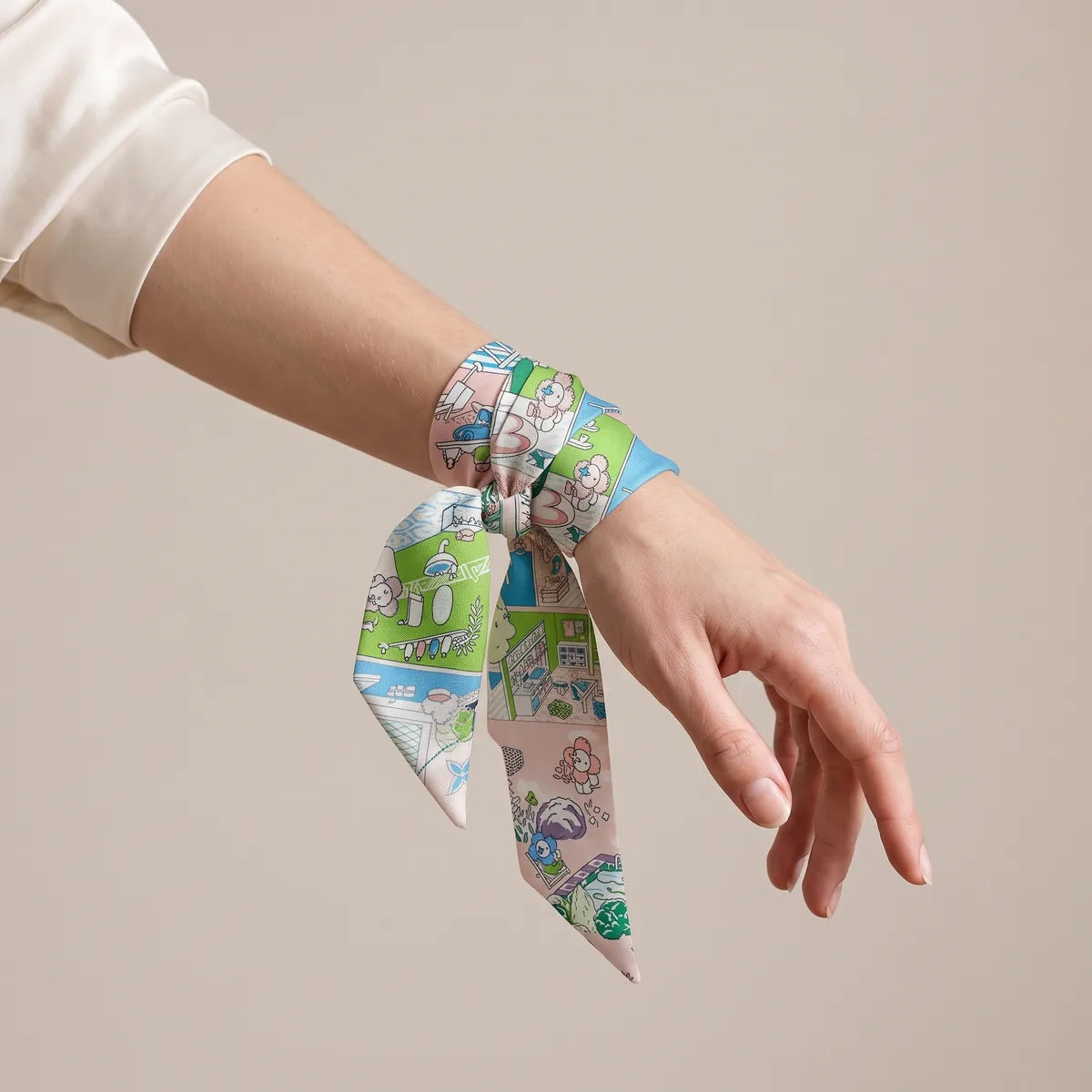 Blush and lime skinny scarf knotted around the wrist, pastel ends hanging