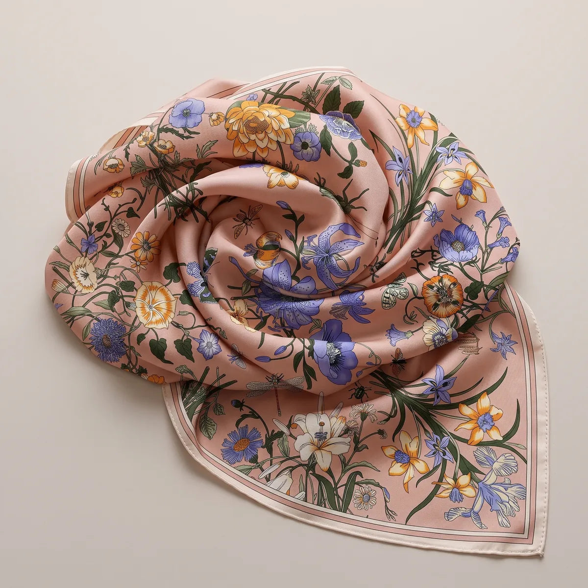 Pink floral shawl coiled into a spiral, periwinkle poppies and an orange flower in the folds