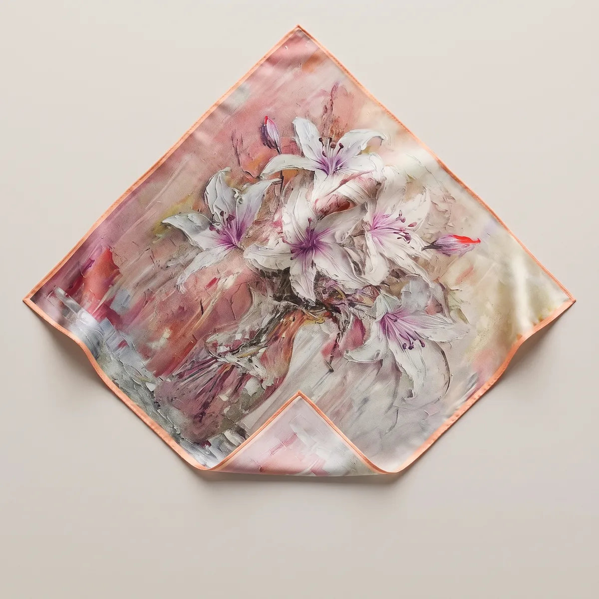 Pink lily floral silk bandana laid flat as a diamond, white lilies on dusty pink, one corner folded to the paler reverse