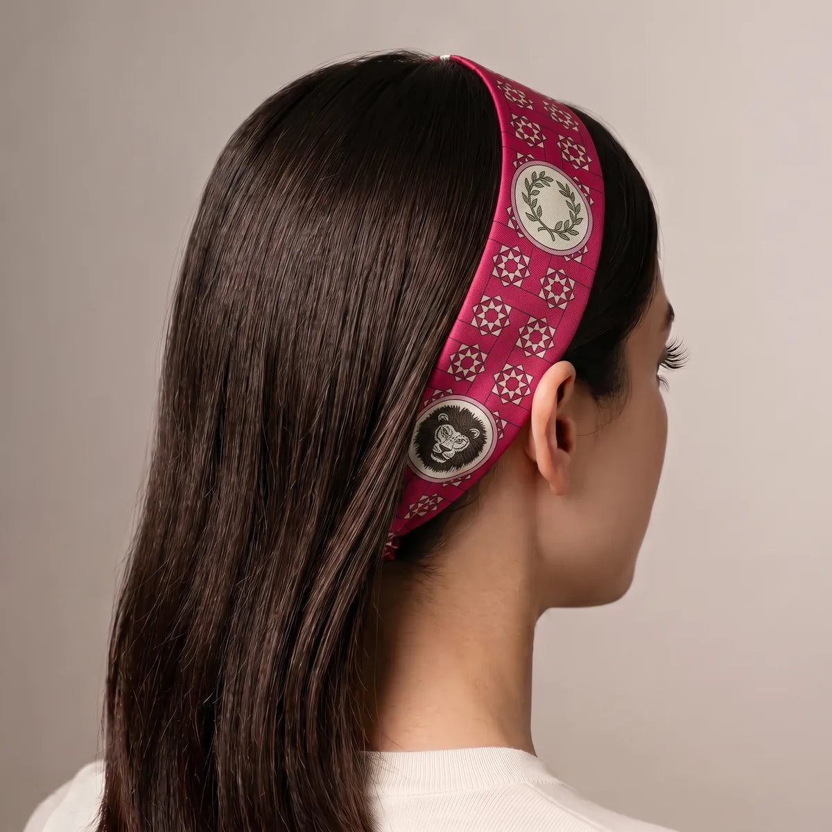 Pink medallion skinny scarf worn as a headband, laurel and lion medallions along the band