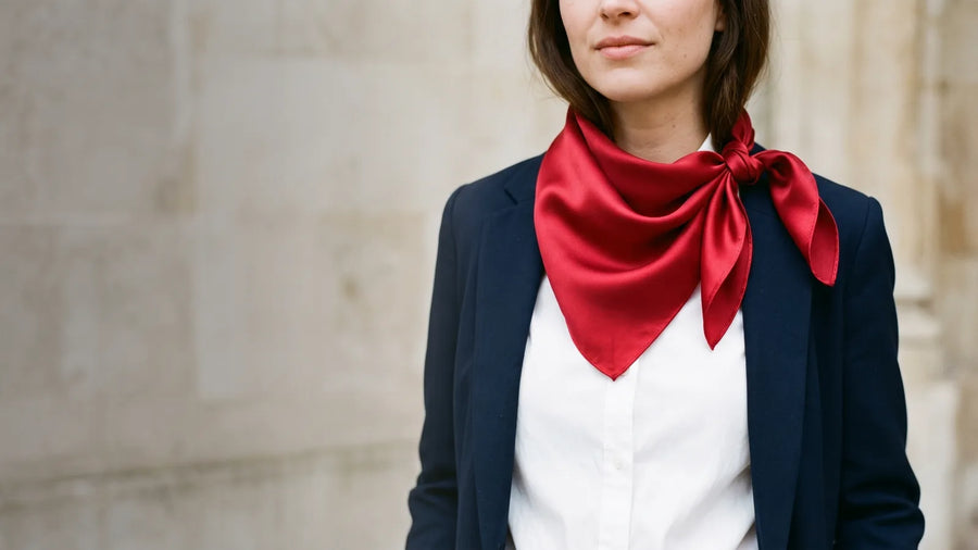 Cherry red silk bandana knotted at the neck with a navy blazer and white shirt