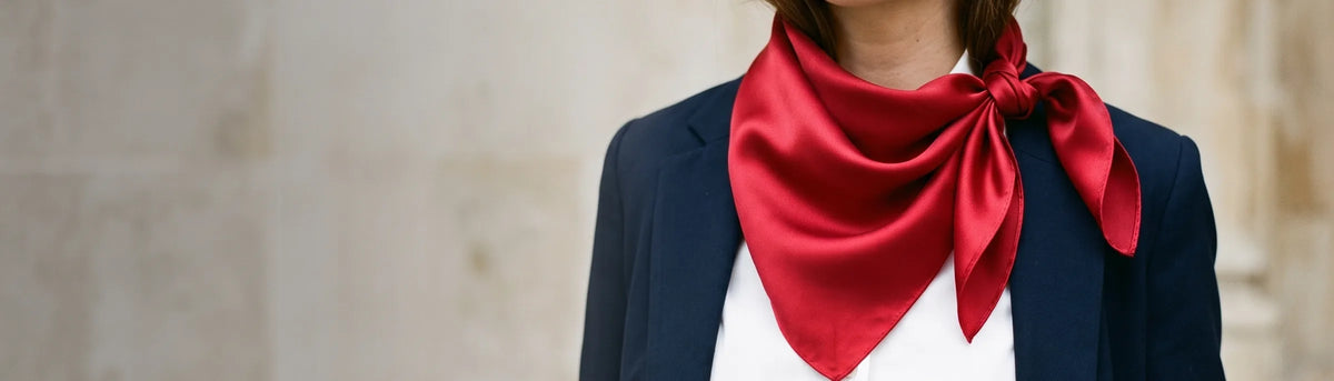 Cherry red silk bandana knotted at the neck with a navy blazer and white shirt