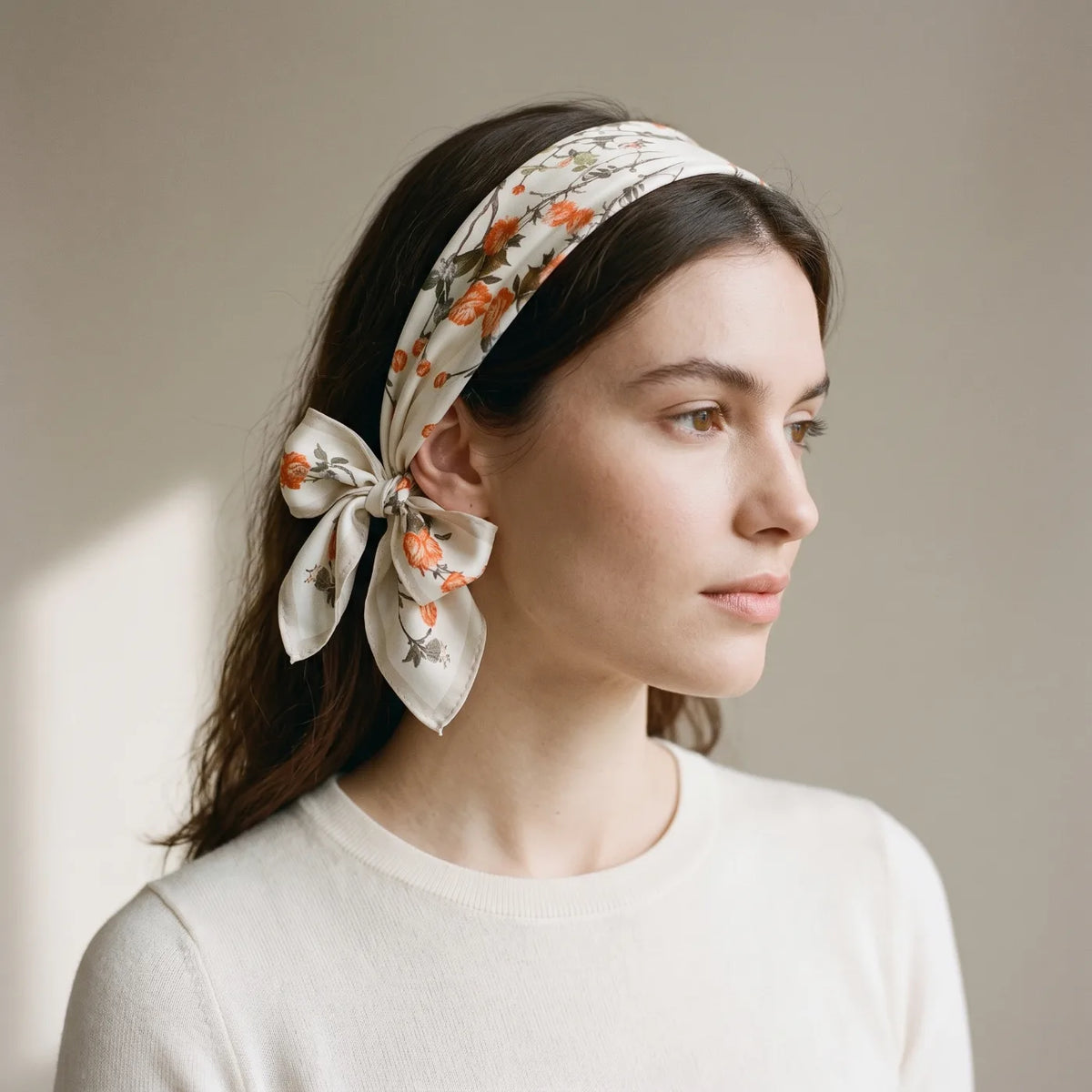 Cream blossom silk bandana worn as a headband with a bow at the side