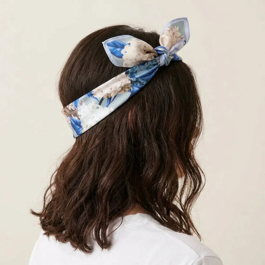 Hydrangea print silk bandana folded into a band and knotted on top of the head