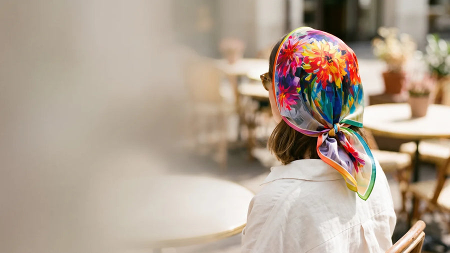Floral silk bandana worn as a kerchief and knotted at the nape at a cafe terrace