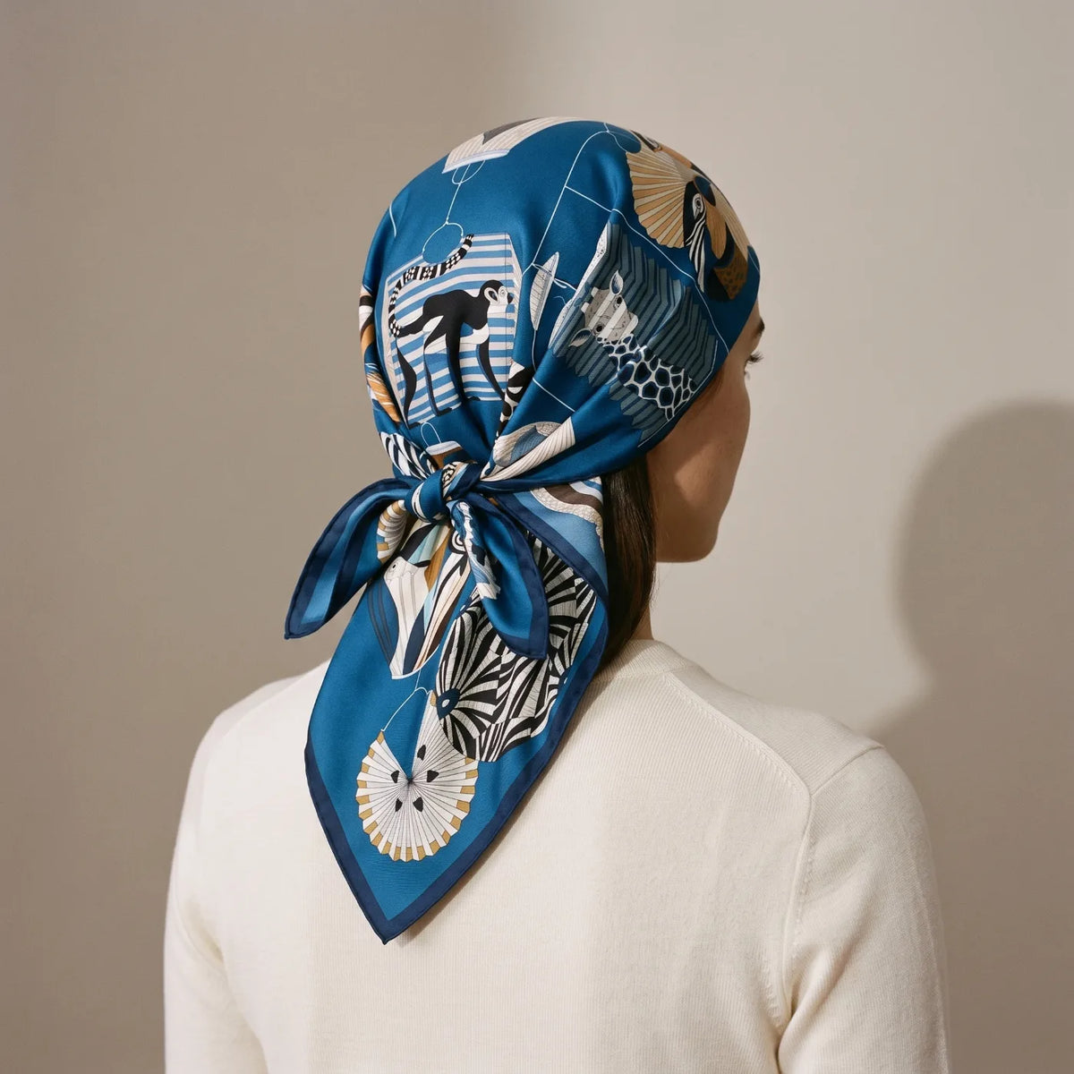 Blue lantern print silk square worn as a full head wrap knotted at the nape