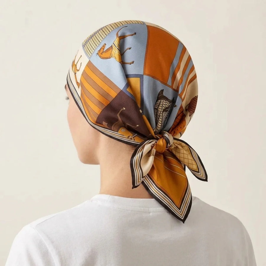 Horse print silk square scarf covering the head and tied behind