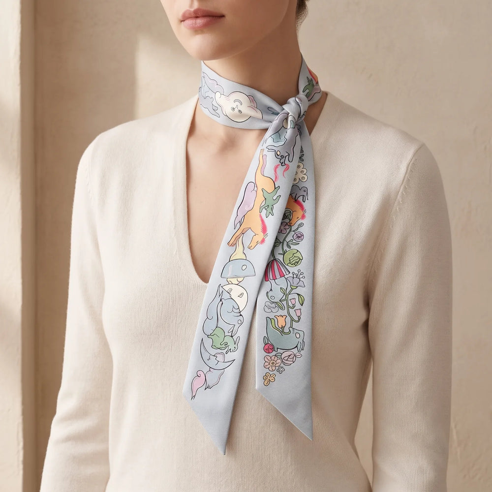 Light blue skinny silk scarf looped once and knotted at the side of the neck