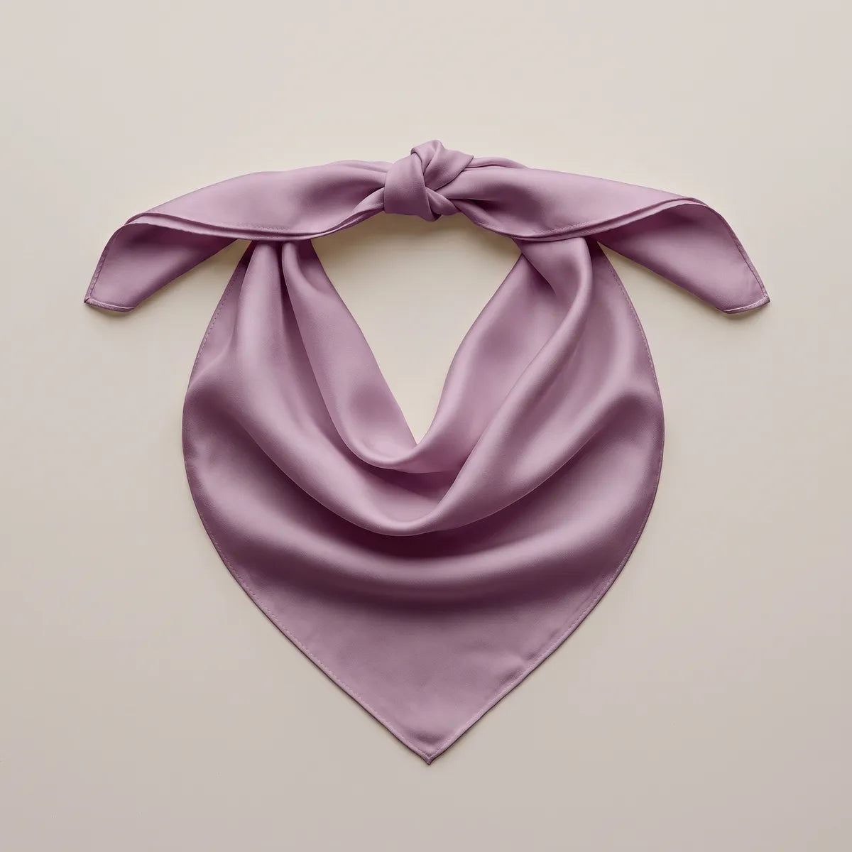 Dusty lilac bandana knotted at two corners and spread out, the point hanging below