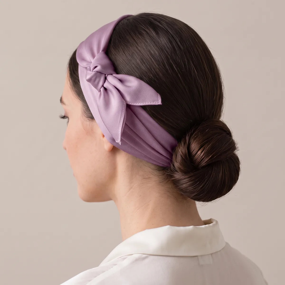Lilac silk scarf folded into a band around the head, knot above the ear, hair pulled into a bun