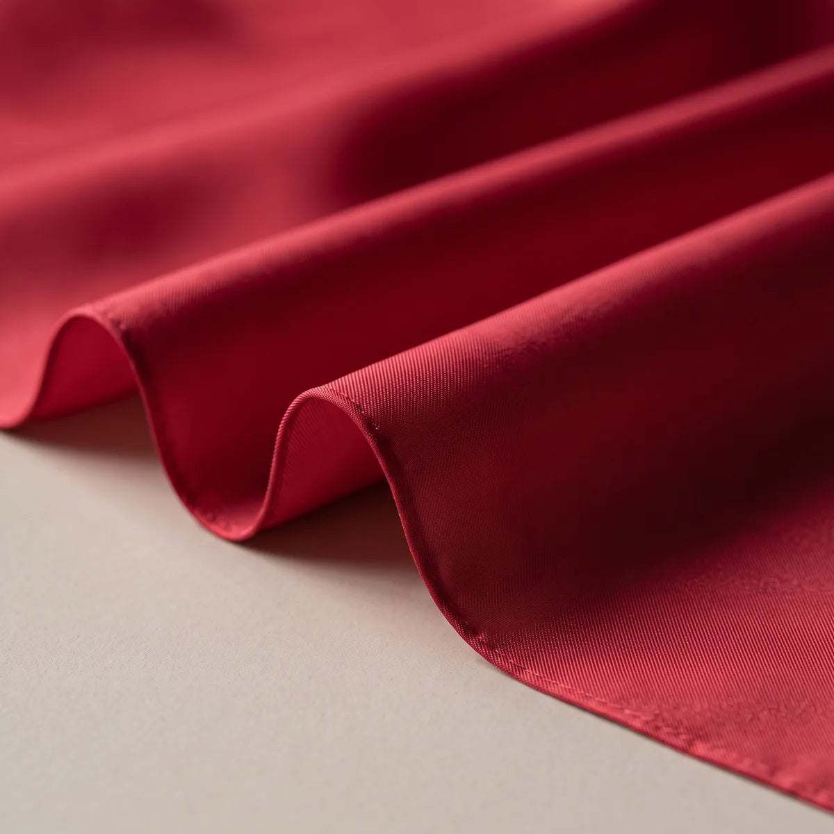 Deep red silk in wide soft folds, brighter where it stretches and darker in the hollows