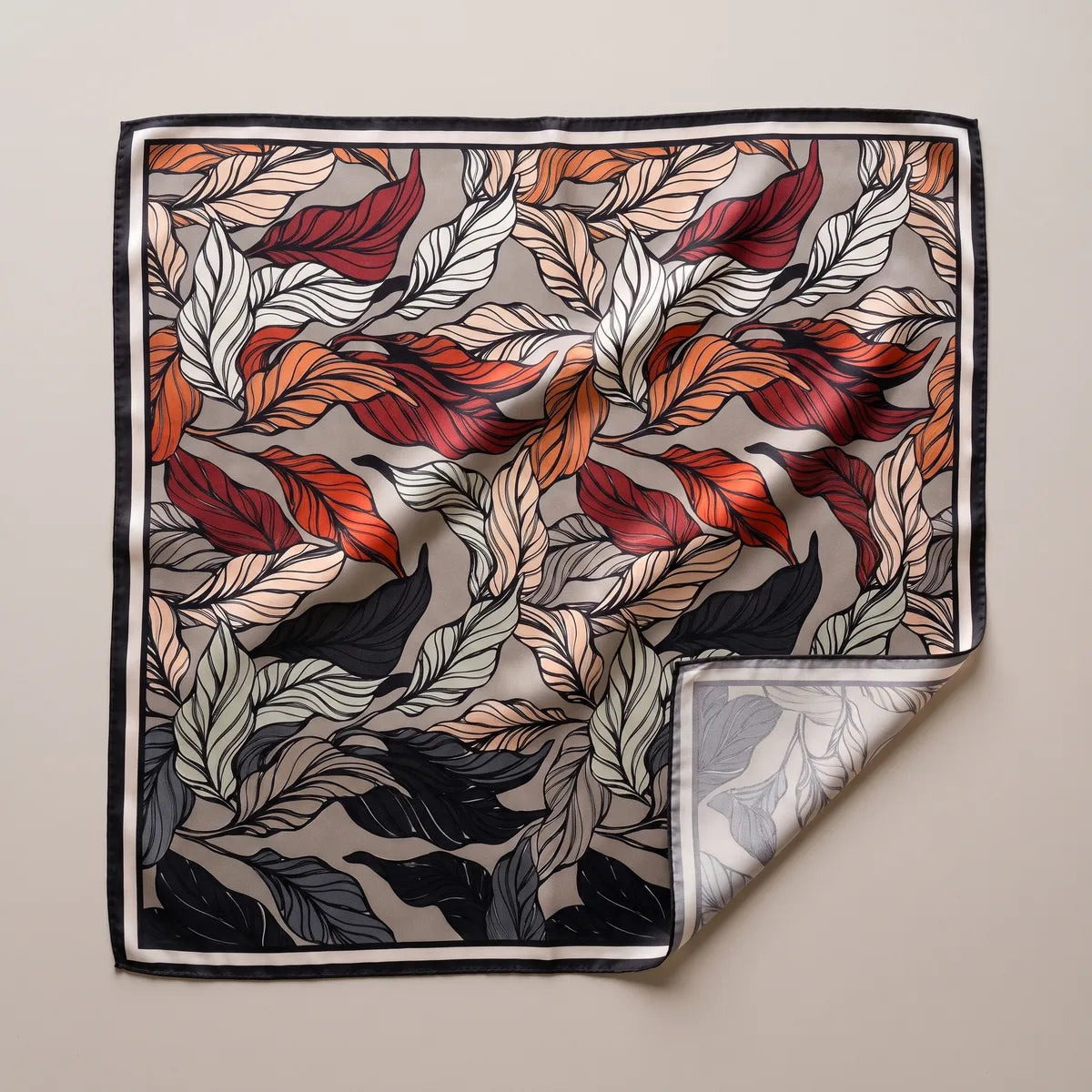 Taupe leaf print silk square scarf laid flat: rust, burgundy, black and sage leaves, black and cream striped border