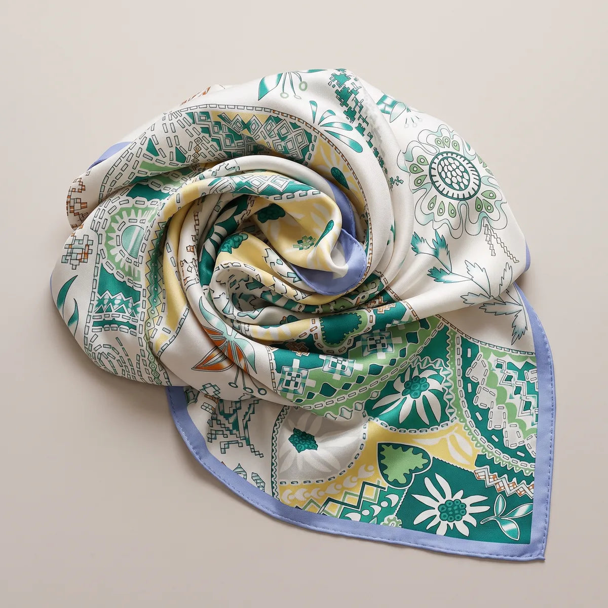 Teal and white patchwork silk shawl swirled into a rose, butter yellow patches showing between the folds
