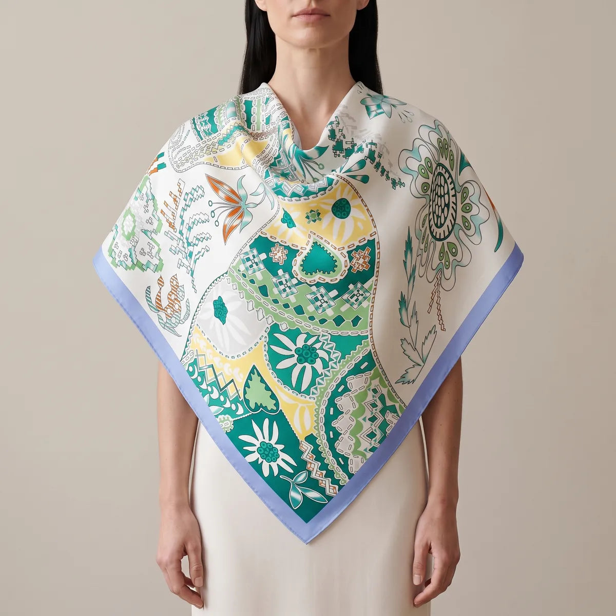 Woman wearing the white and teal patchwork silk shawl across her shoulders, periwinkle border at the point